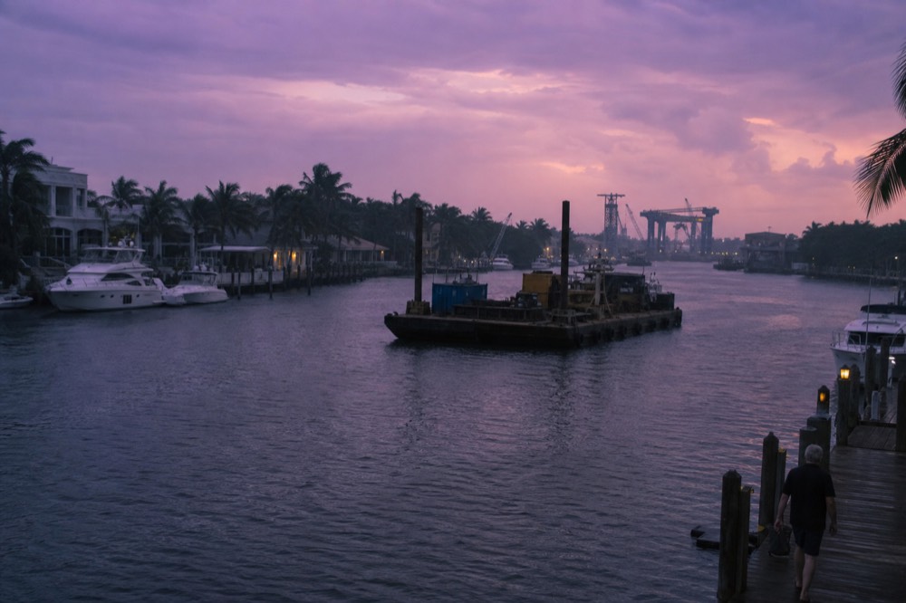 Waterfront mansions and docked boats along a Fort Lauderdale canal at dusk, no text, no logos, no people