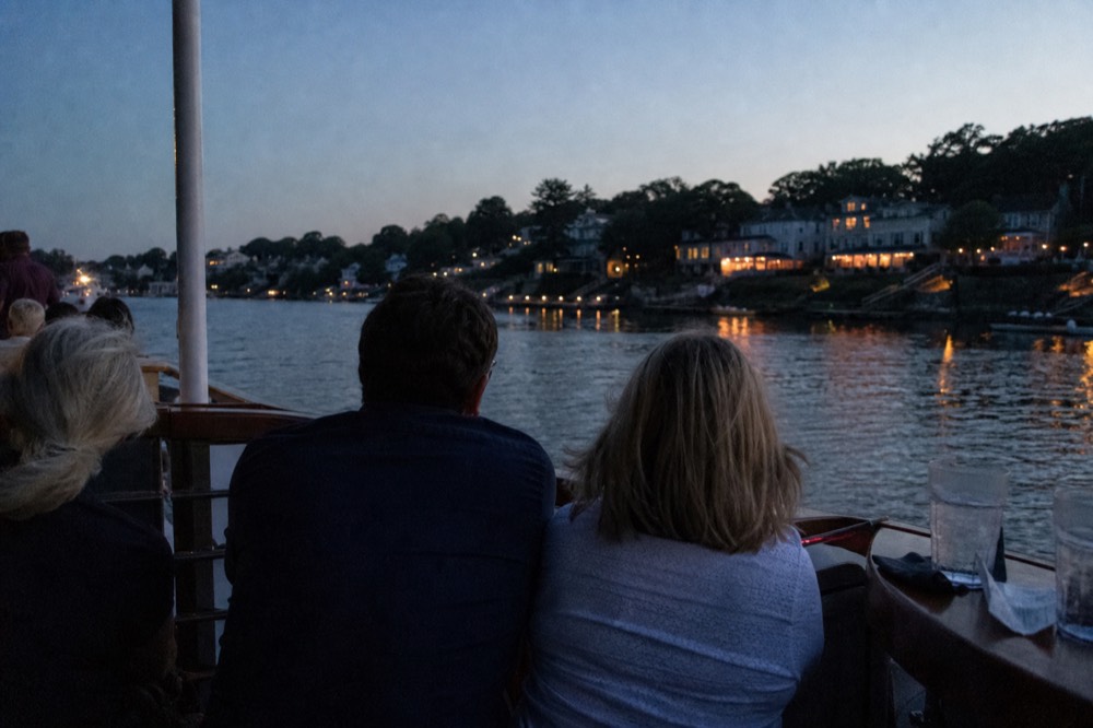 Passengers on a sunset cruise with drinks in hand, no text, no logos, no people