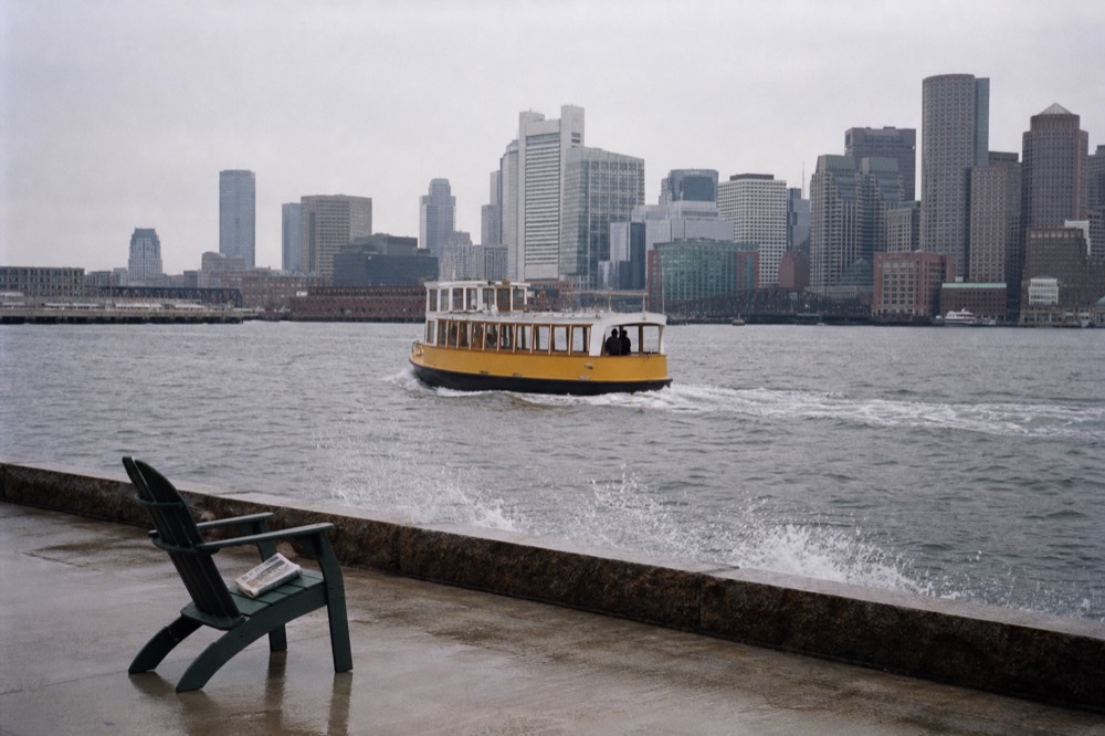Yellow LauderGO Water Trolley vessel cruising the New River with the downtown skyline behind, no text, no logos, no people
