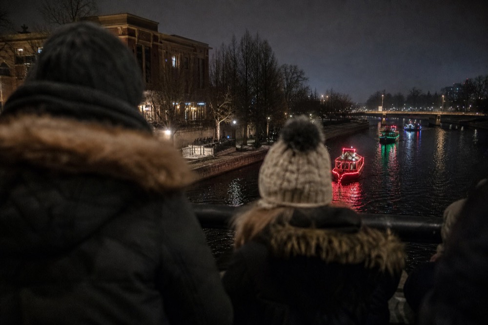 Decorated boats with lights on a nighttime waterway parade, no text, no logos, no people.